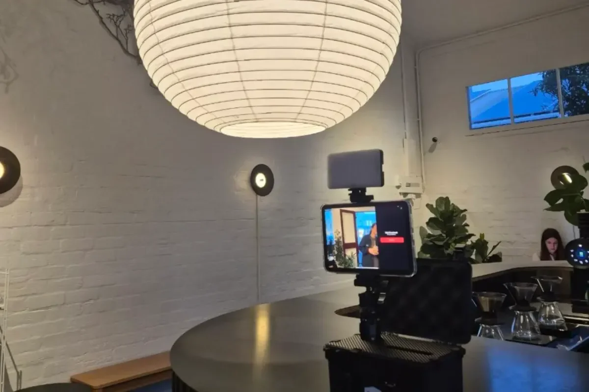 Memory Vault ready for guests in a café: a tablet showing the live camera view, with a light panel above it, mounted on the black printer case.