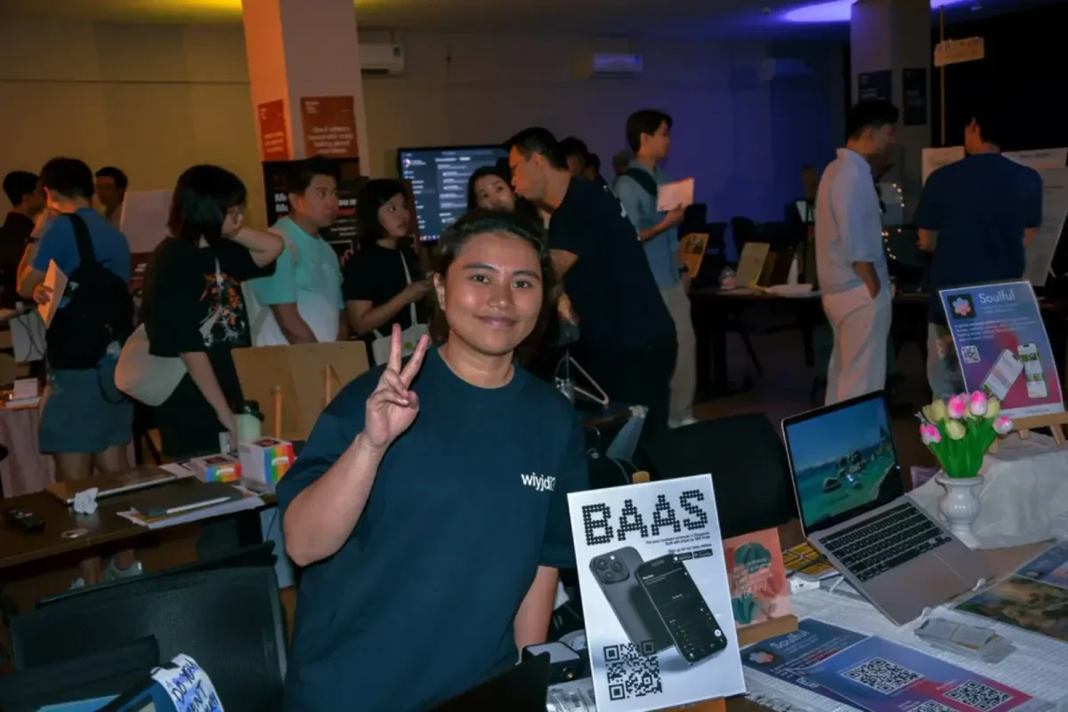 A showcase stand with the BAAS beta poster and sign-up QR code at the front, with a crowd of visitors behind it.
