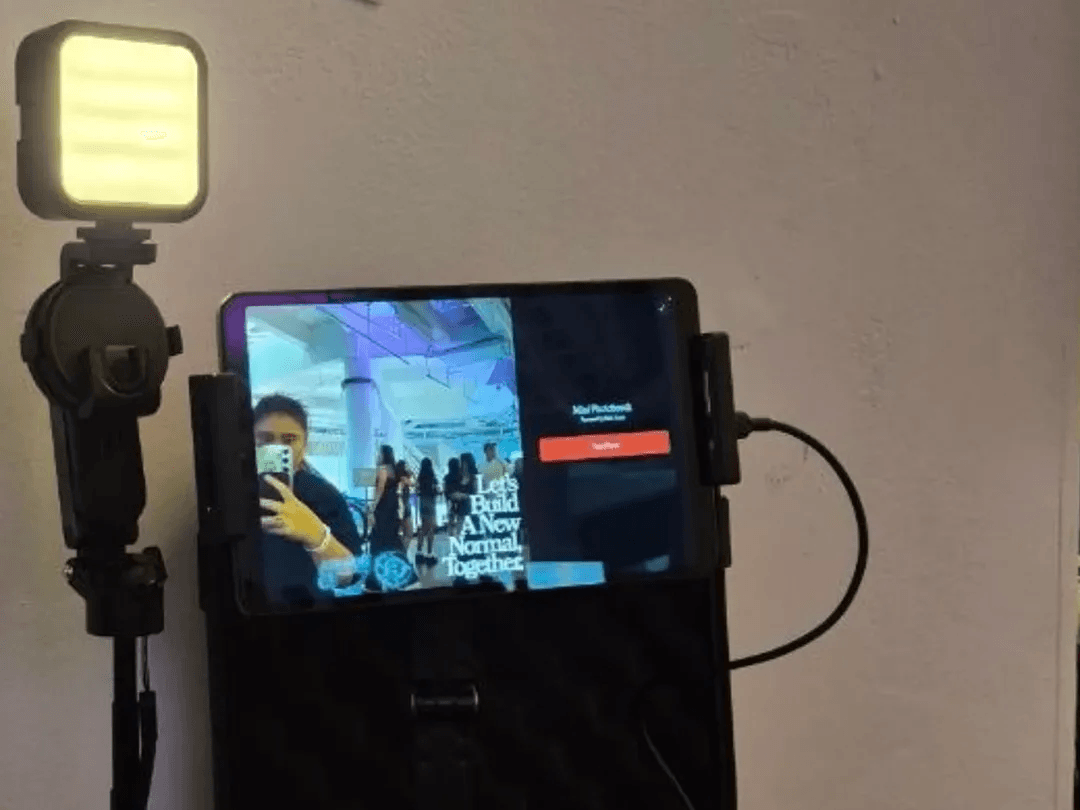 Memory Vault set up at Youth Day '26: a light panel and a tablet showing the live camera view, mounted on the open black case.